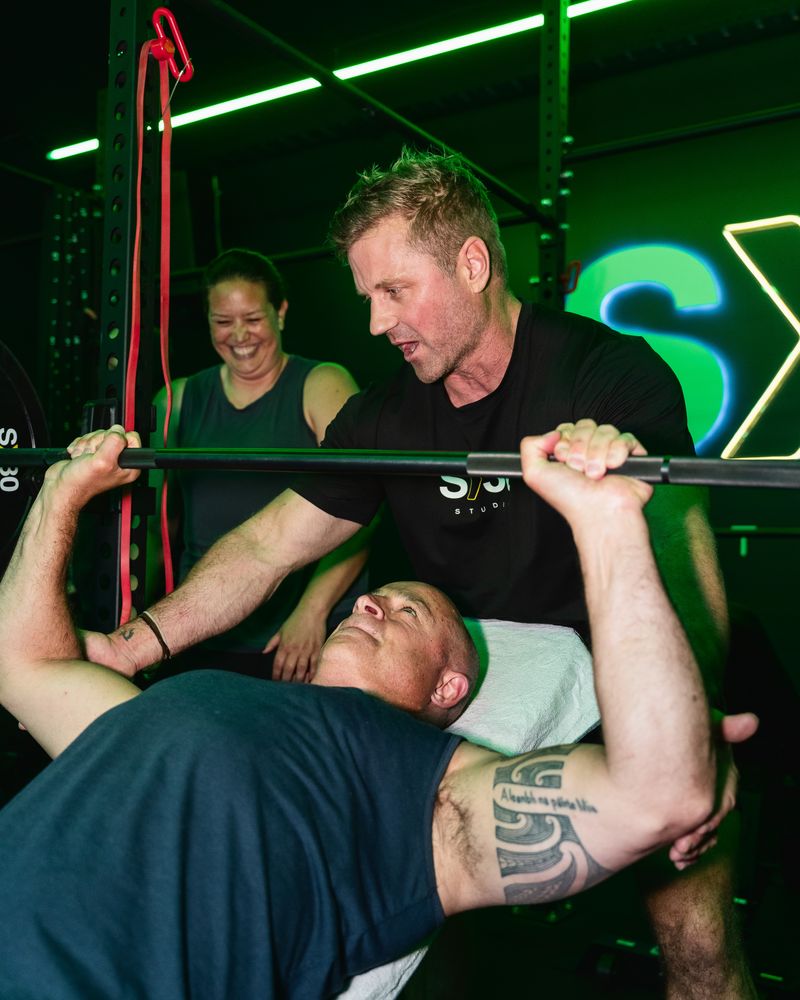 A coach spotting a bench press